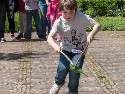 Kind hält mit zwei Stöcken ein Blatt