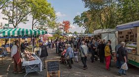 Personen auf einem Wochenmarkt an Verkaufsständen