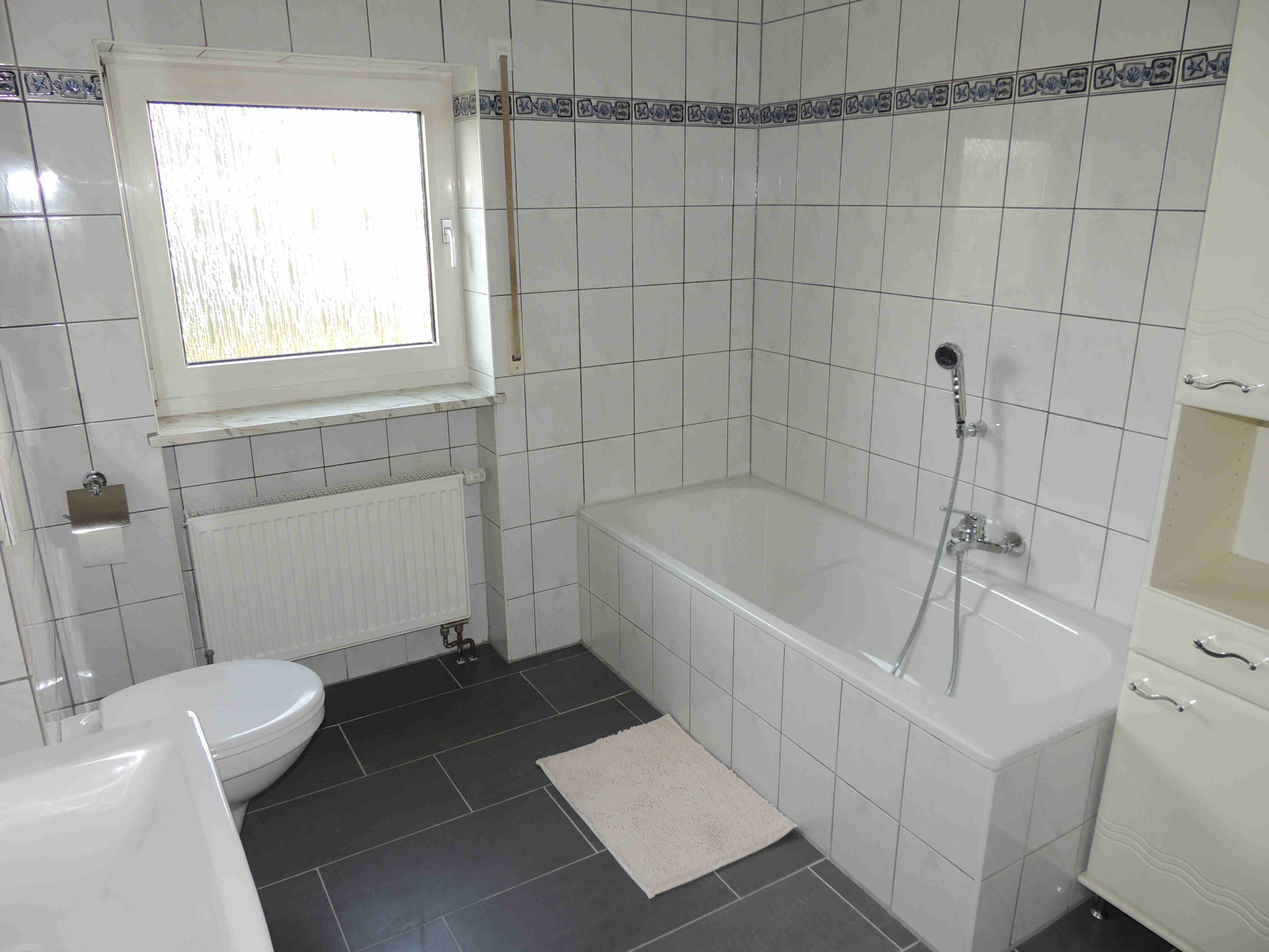 Badezimmer mit Badewanne und WC