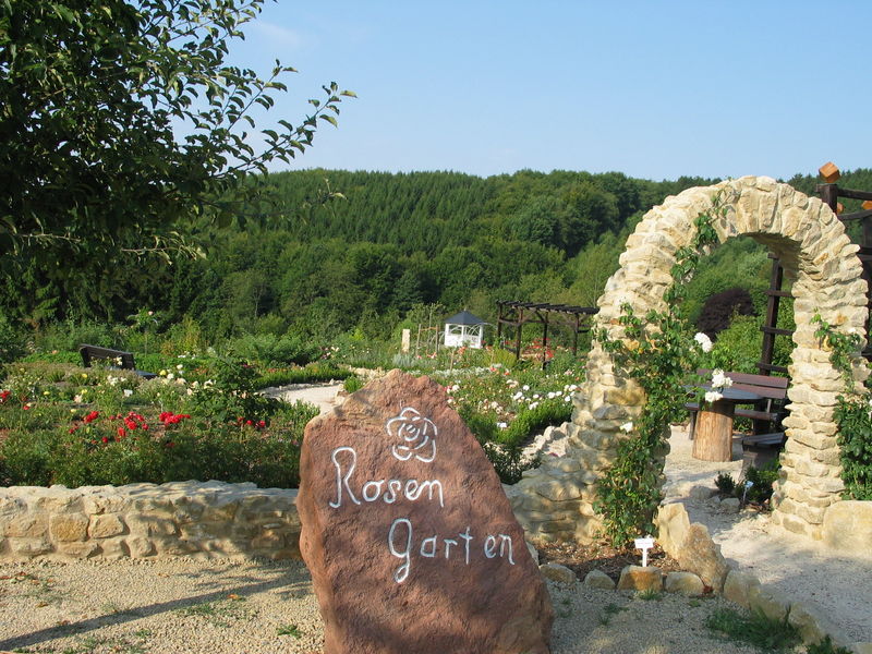 Torbogen aus Steinen als Eingang zum Rosengarten
